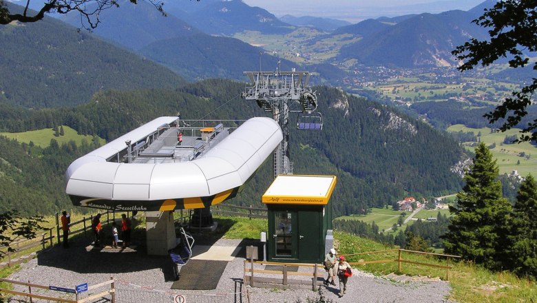 Summit station of the Schneeberg chairlift with a view of the surrounding mountains and valleys.