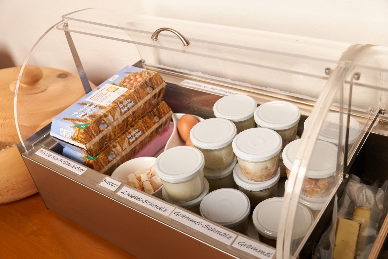 A fridge compartment with organic eggs, jars of lard and butter.
