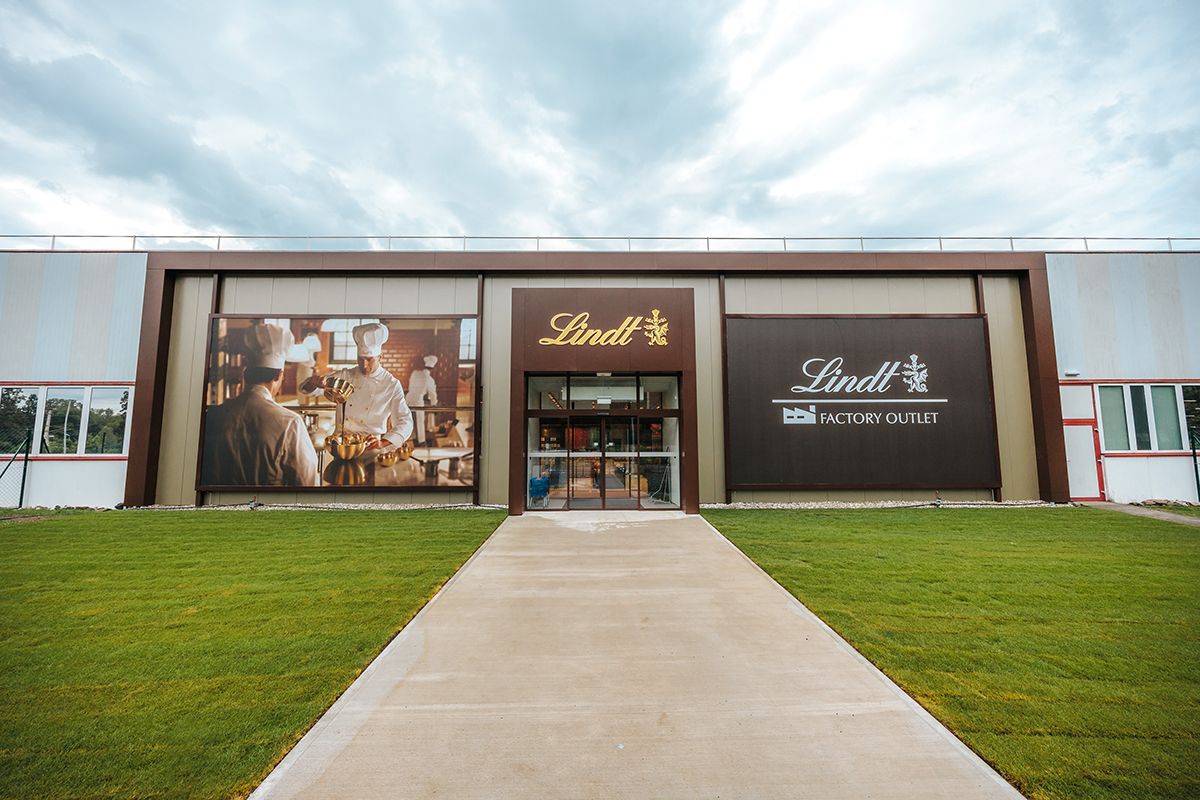 Entrance to the Lindt Factory Outlet with large advertising banners.
