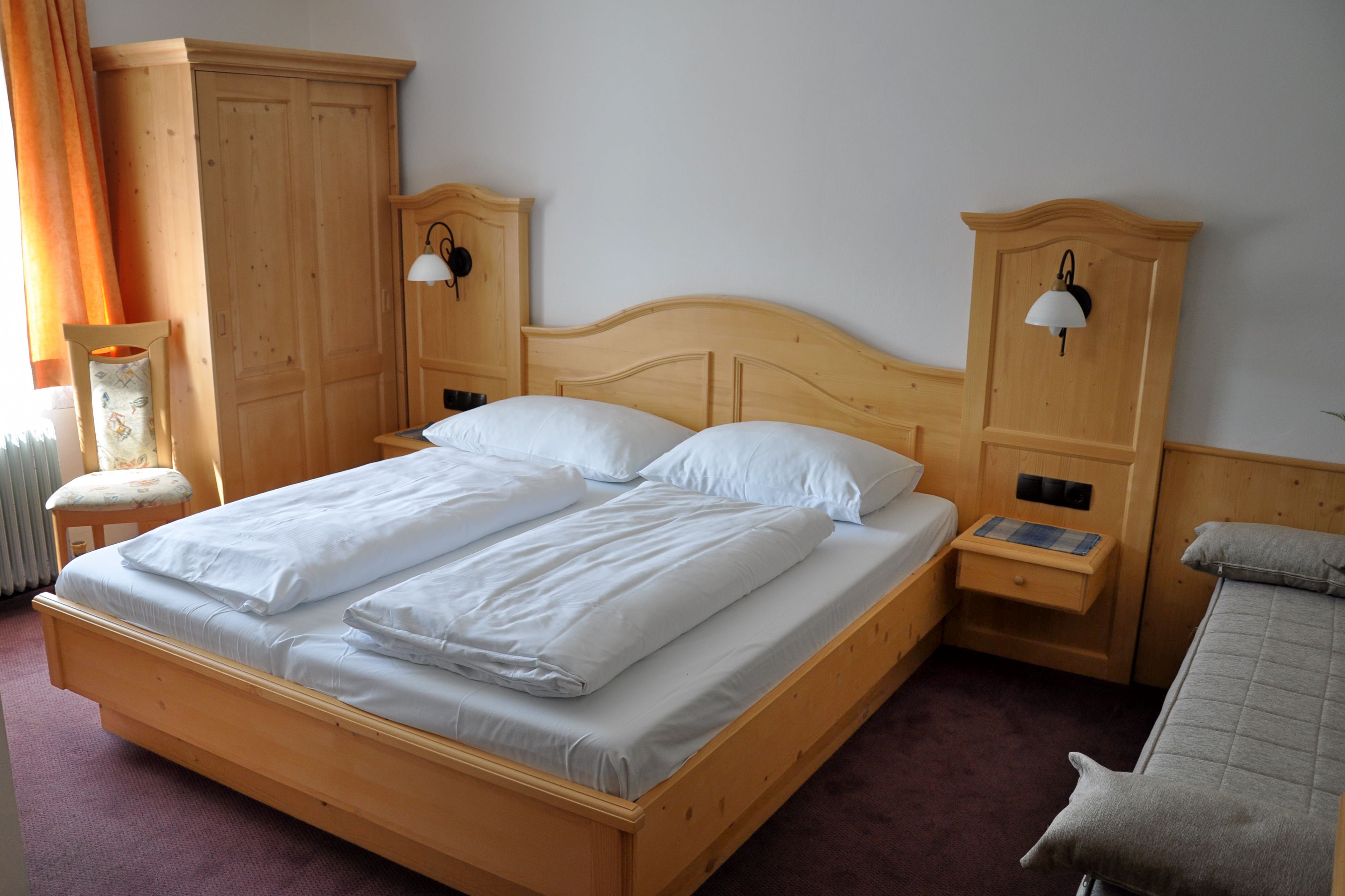 Comfort room with double bed and solid wood furniture.