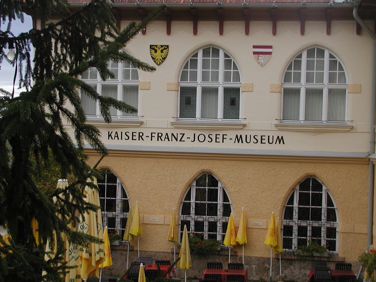 Facade of the Kaiser-Franz-Josef-Museum with windows and coat of arms.