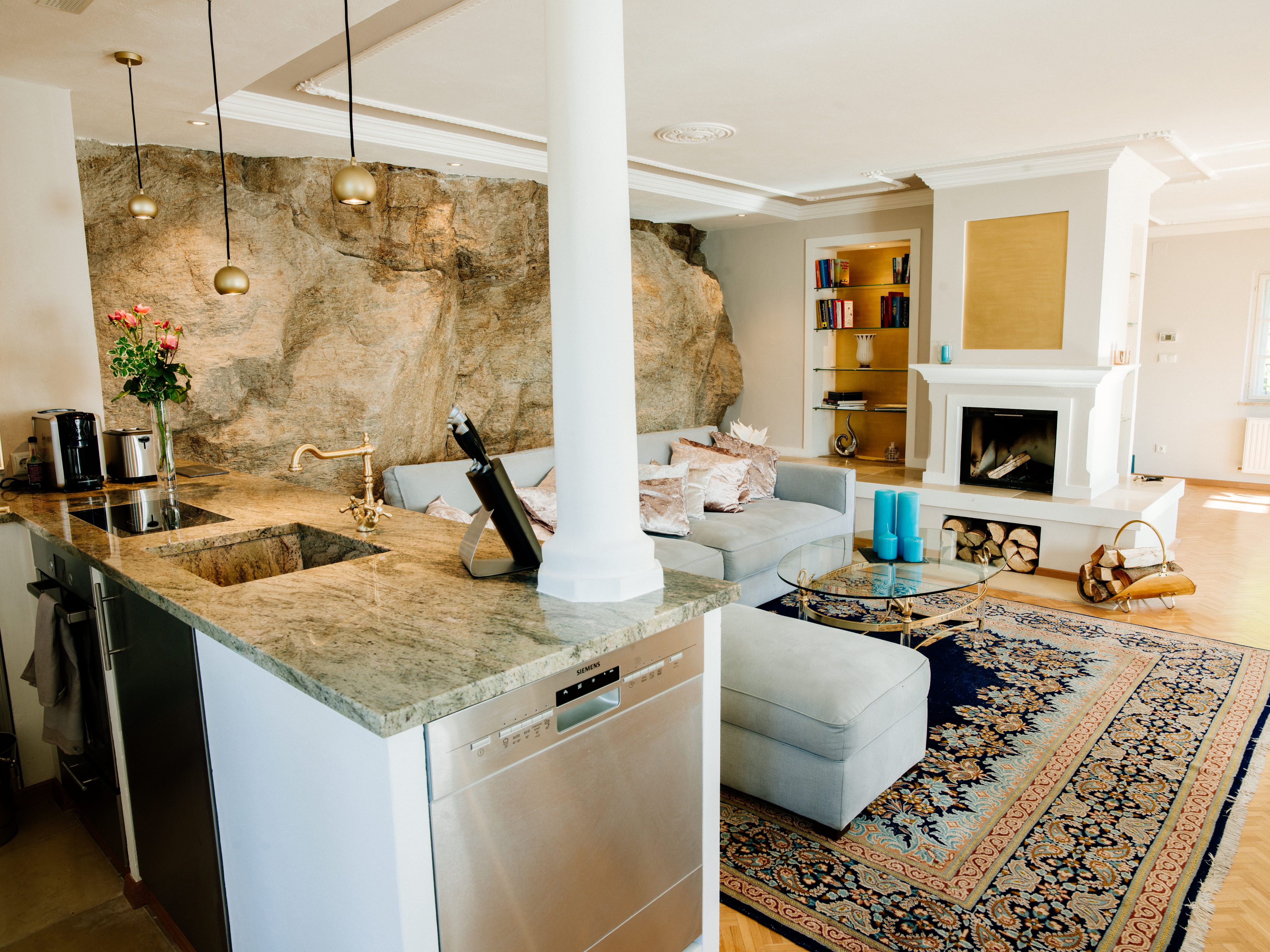 Elegant living room with fireplace, carpet and open kitchen.