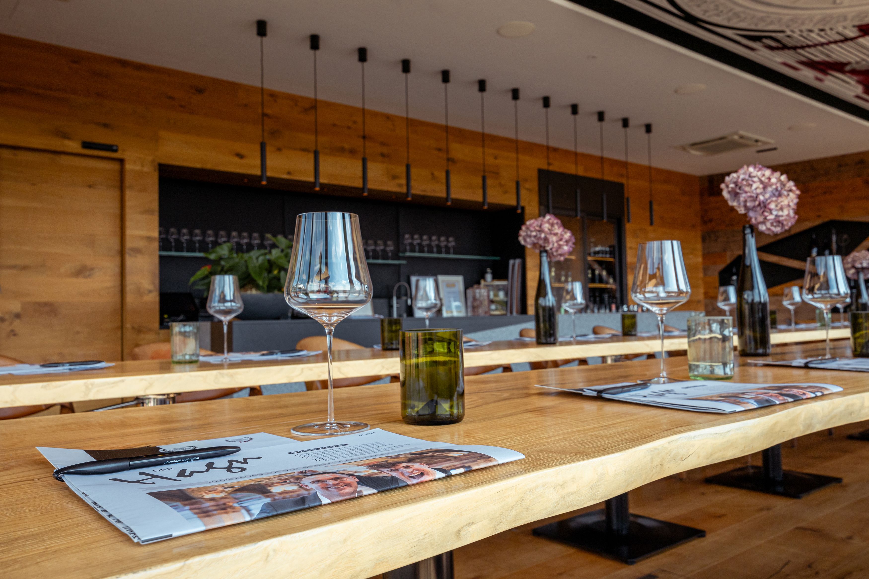 Interior view of a modern wine domicile with laid tables, wine glasses and decoration.