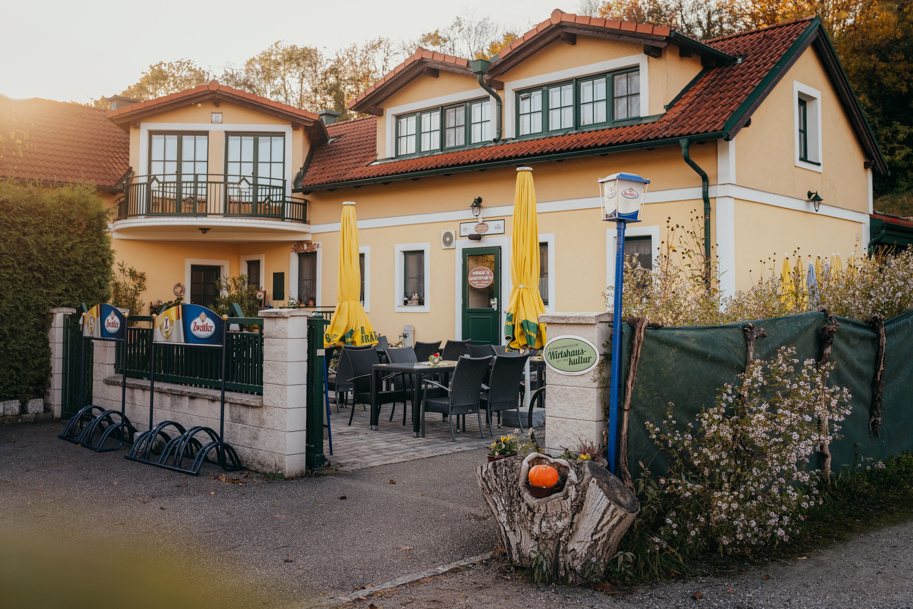 Restaurant with terrace, yellow parasols and floral decor.