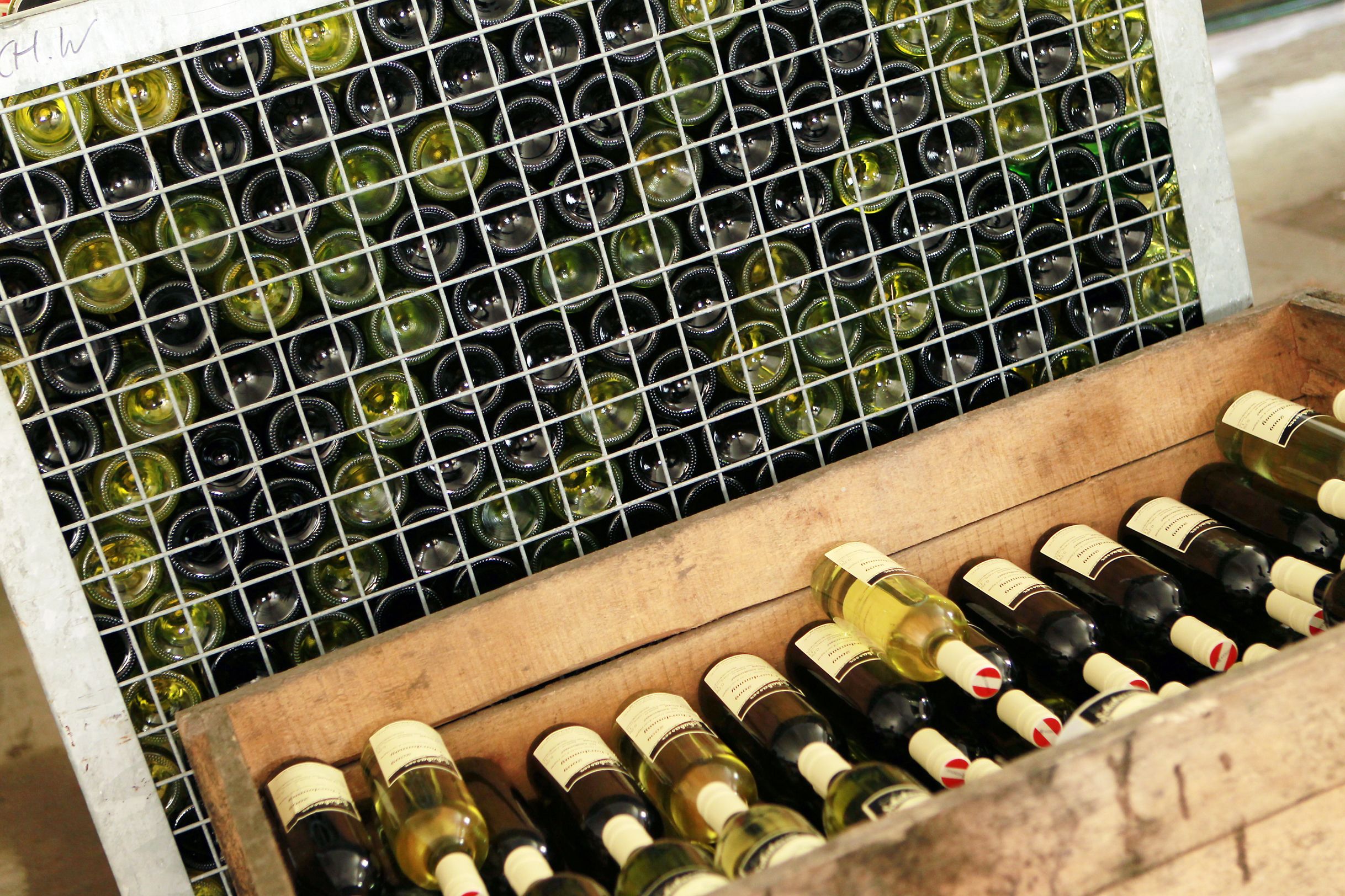 Wine bottles in a lattice rack and a wooden crate.