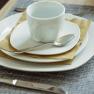 Table set with white crockery, cup and cutlery.