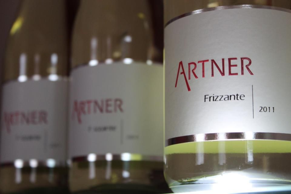 Close-up of wine bottles with the label 'Artner Frizzante 2011'.