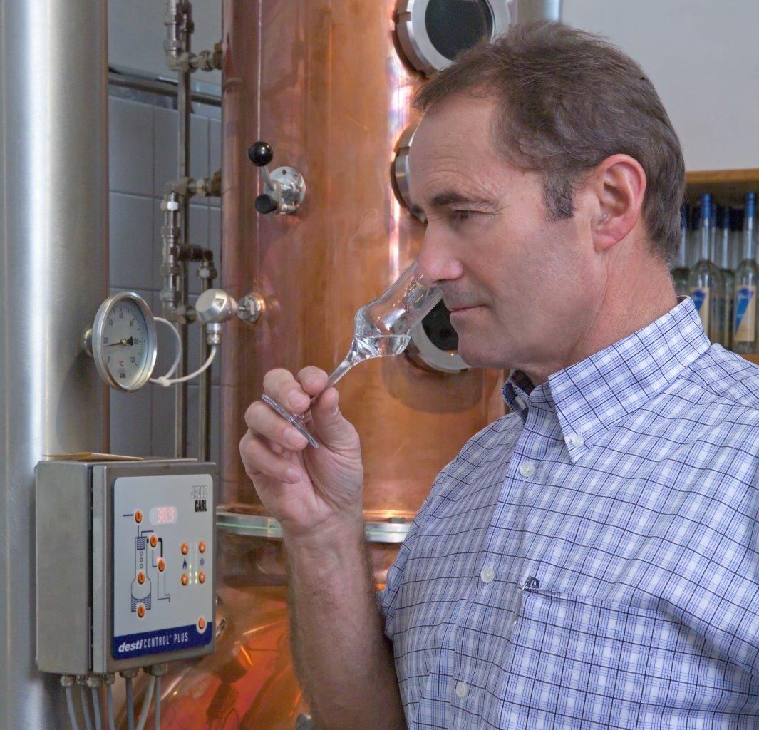 Man smelling a glass in a distillery.