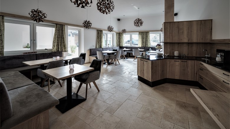 Modern breakfast room with wooden furniture, gray upholstery and decorative lamps.
