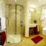 Modern bathroom with shower, washbasin and towel rail.