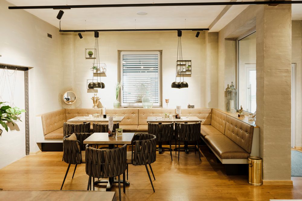 Modern restaurant with stylish furnishings and cozy bench seating.