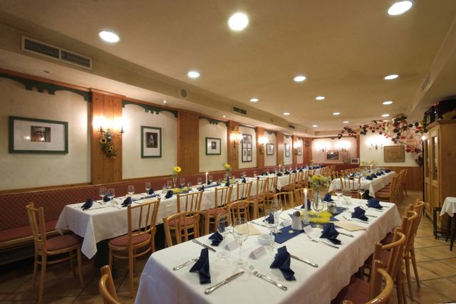 Elegant dining room with laid tables and blue napkins.