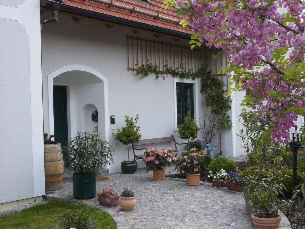 Entrance to a country house with flowering plants and a barrel.