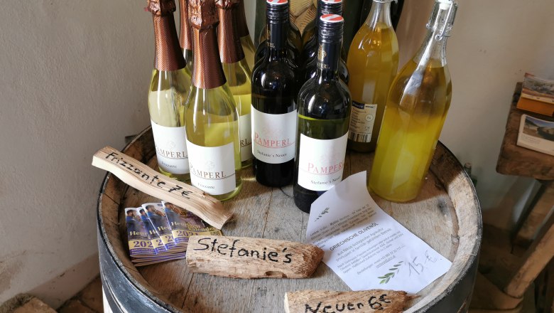 Wine bottles and flyers on a barrel.