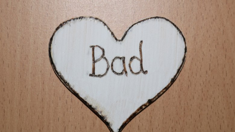 Wooden sign in the shape of a heart with the inscription 'Bad'.