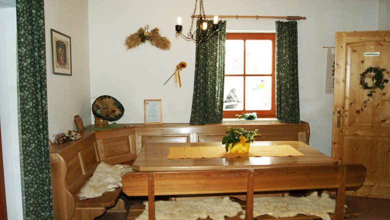 Cozy lounge with wooden furniture, table, corner bench and decorations on the wall.