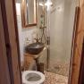 Small bathroom with shower, washbasin and toilet.