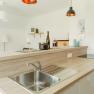 Modern kitchen with wooden worktop, sink and decoration.