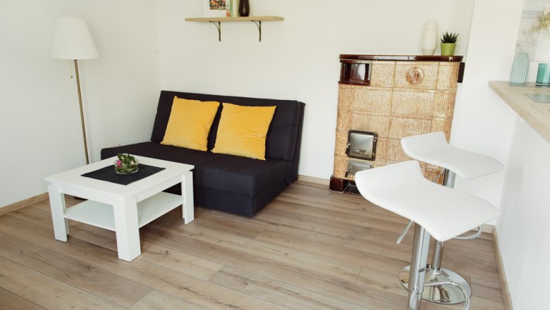 Modern living room with sofa, coffee table, bar stools and fireplace.