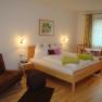 Comfortable hotel room with double bed, sofa and dining table.