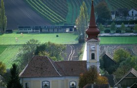 Großriedenthal parish church with church tower and surrounding fields and buildings.
