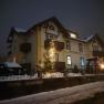 An illuminated building in the snow with Christmas decorations.