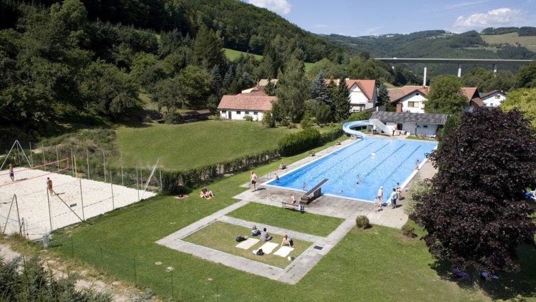 Edlitz outdoor pool with swimming pool, slide and volleyball court in a rural setting.