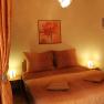 A cozy bedroom with orange decoration and lighting.