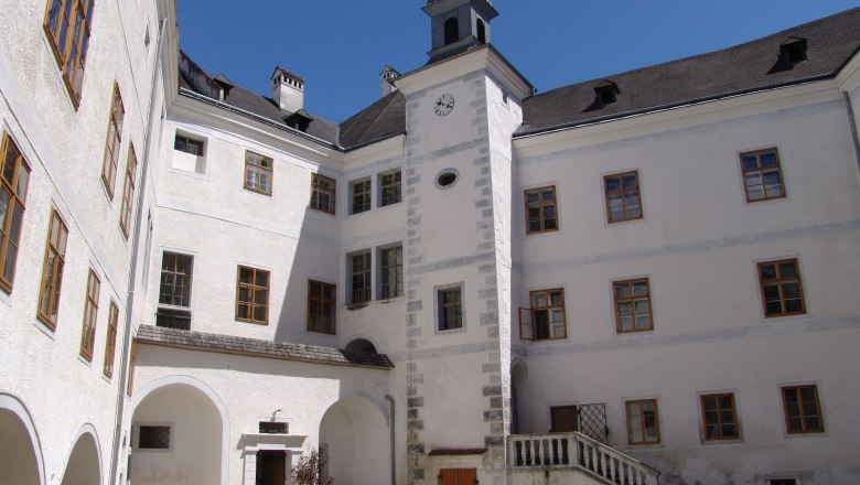 Inner courtyard of Leiben Castle with clock tower and white facades.