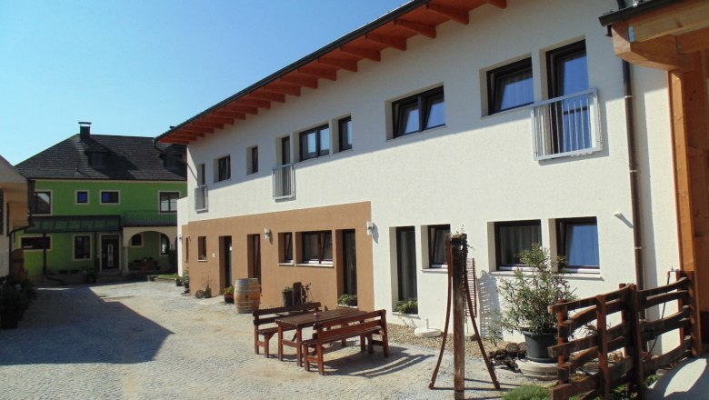Courtyard with modern buildings and wooden outdoor furniture.