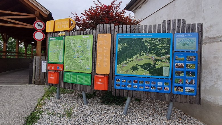 Hiking starting point in Bad Erlach with large information board and maps of the Vienna Alps.