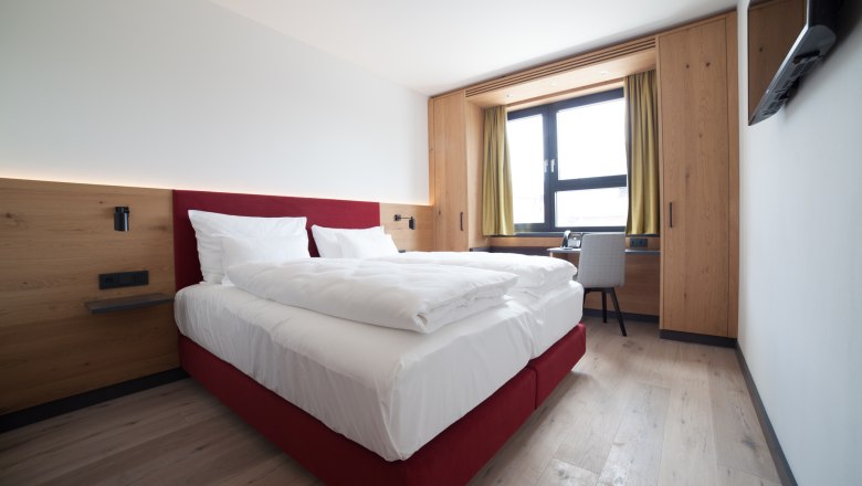 Double bed in bright room with window