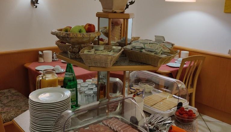 Breakfast buffet with cold cuts, cheese, fruit and drinks.