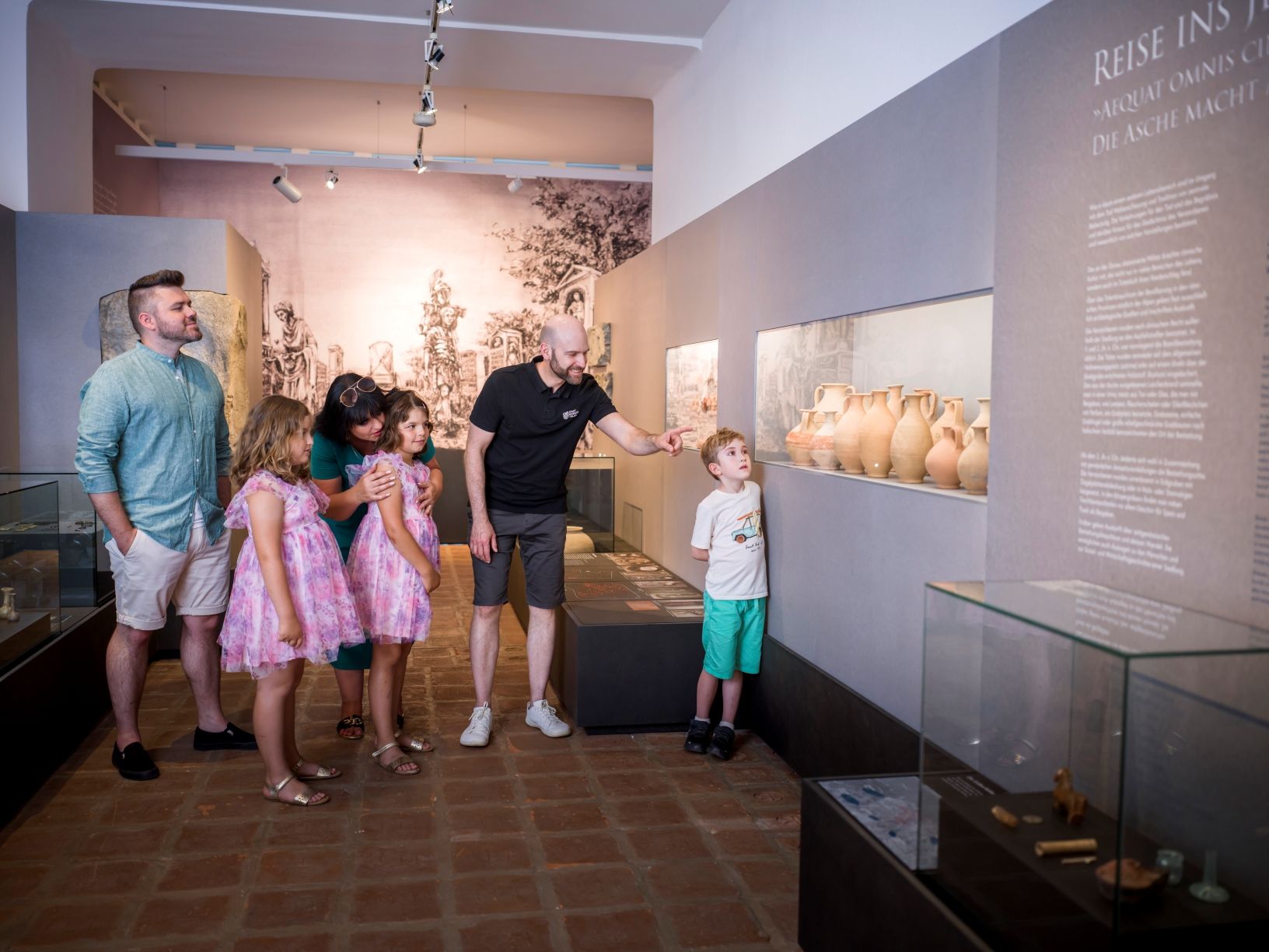 Children and adults are viewing ancient ceramic vases at the city museum,