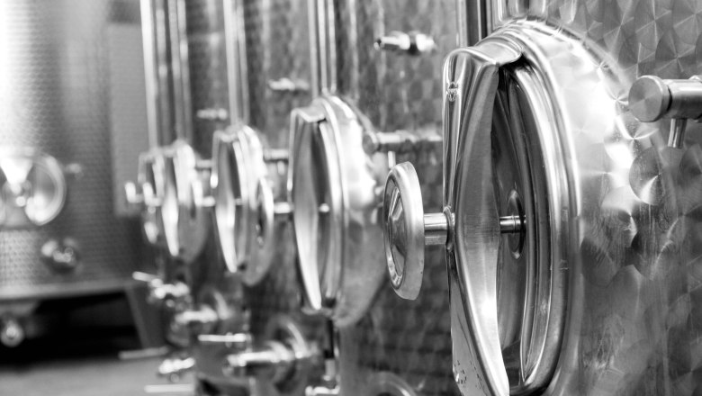 Close-up of stainless steel wine tanks in a row.