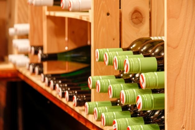 Wine bottles stored in a wooden rack.