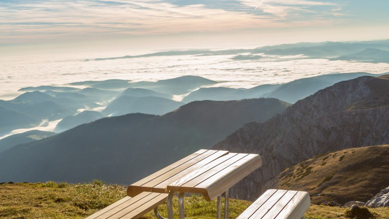 Picnic table on a mountain with a view of the sea of clouds and the sun.
