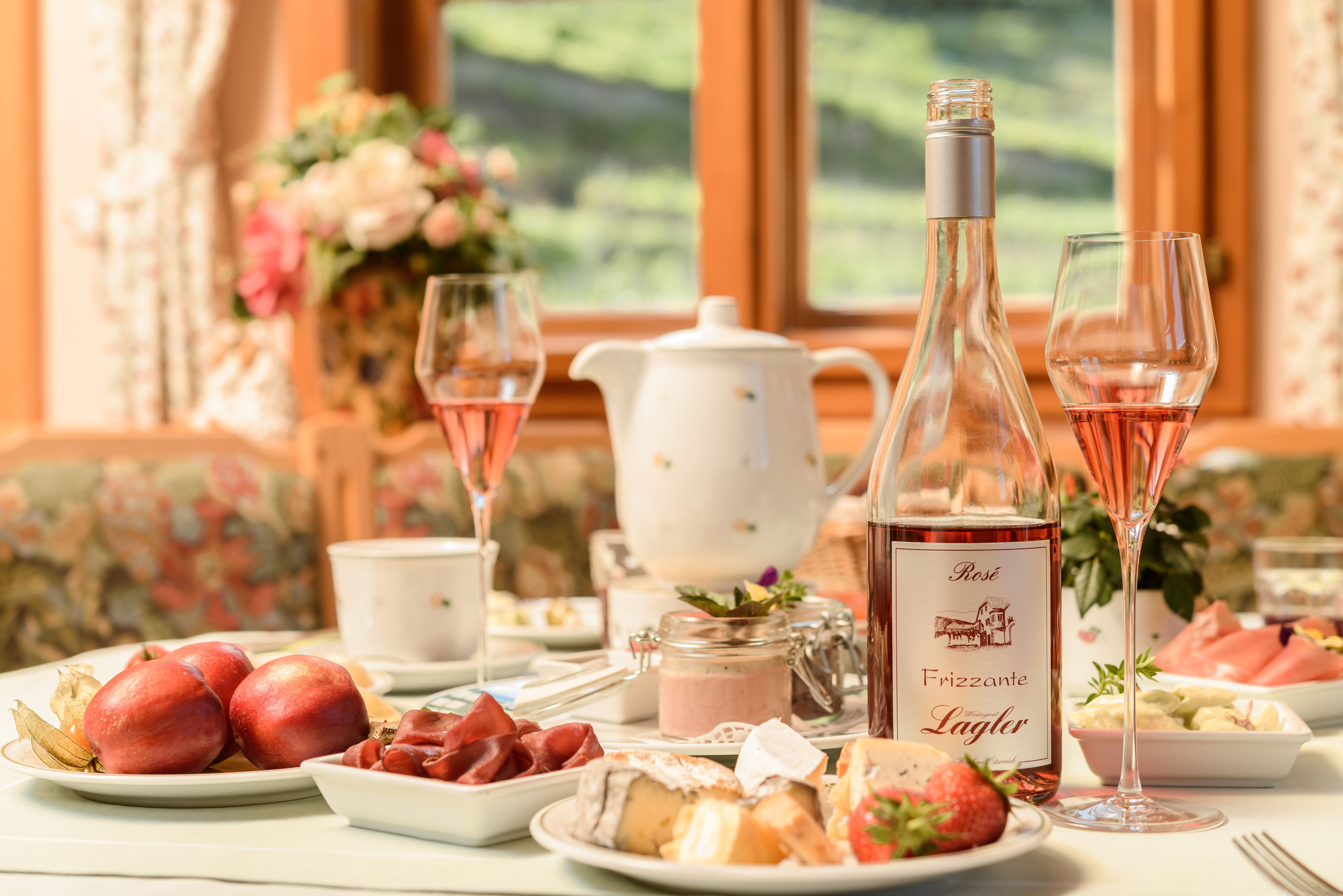 Breakfast table with fruit and cheese and a bottle of Frizzante