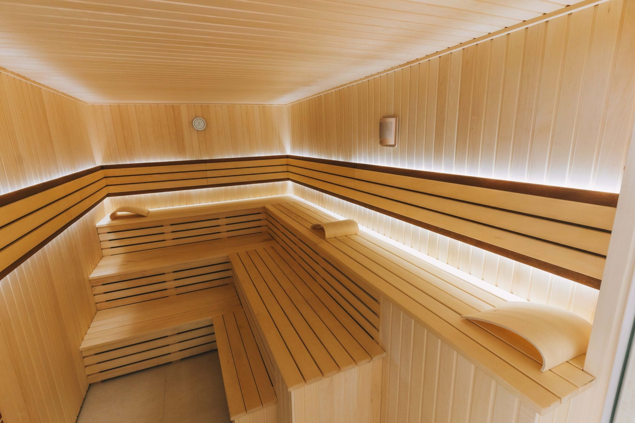 Interior view of a modern sauna with wooden benches and soft lighting.