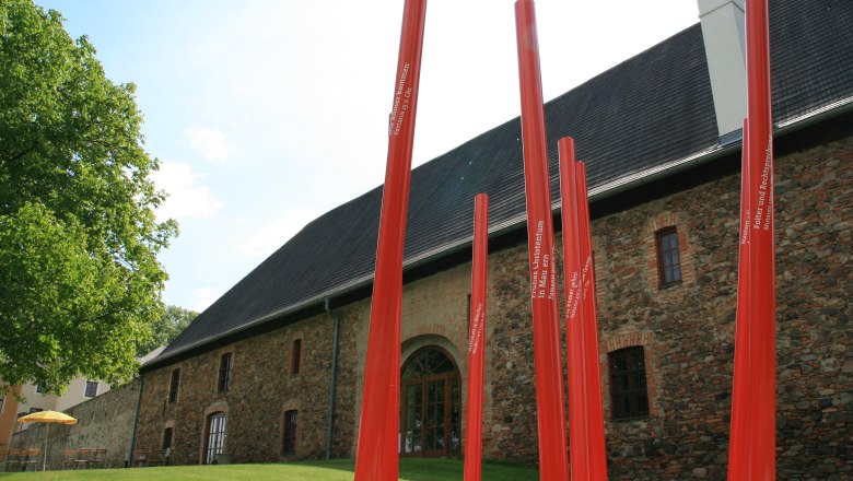 Red poles in front of a historic building in Mautern.