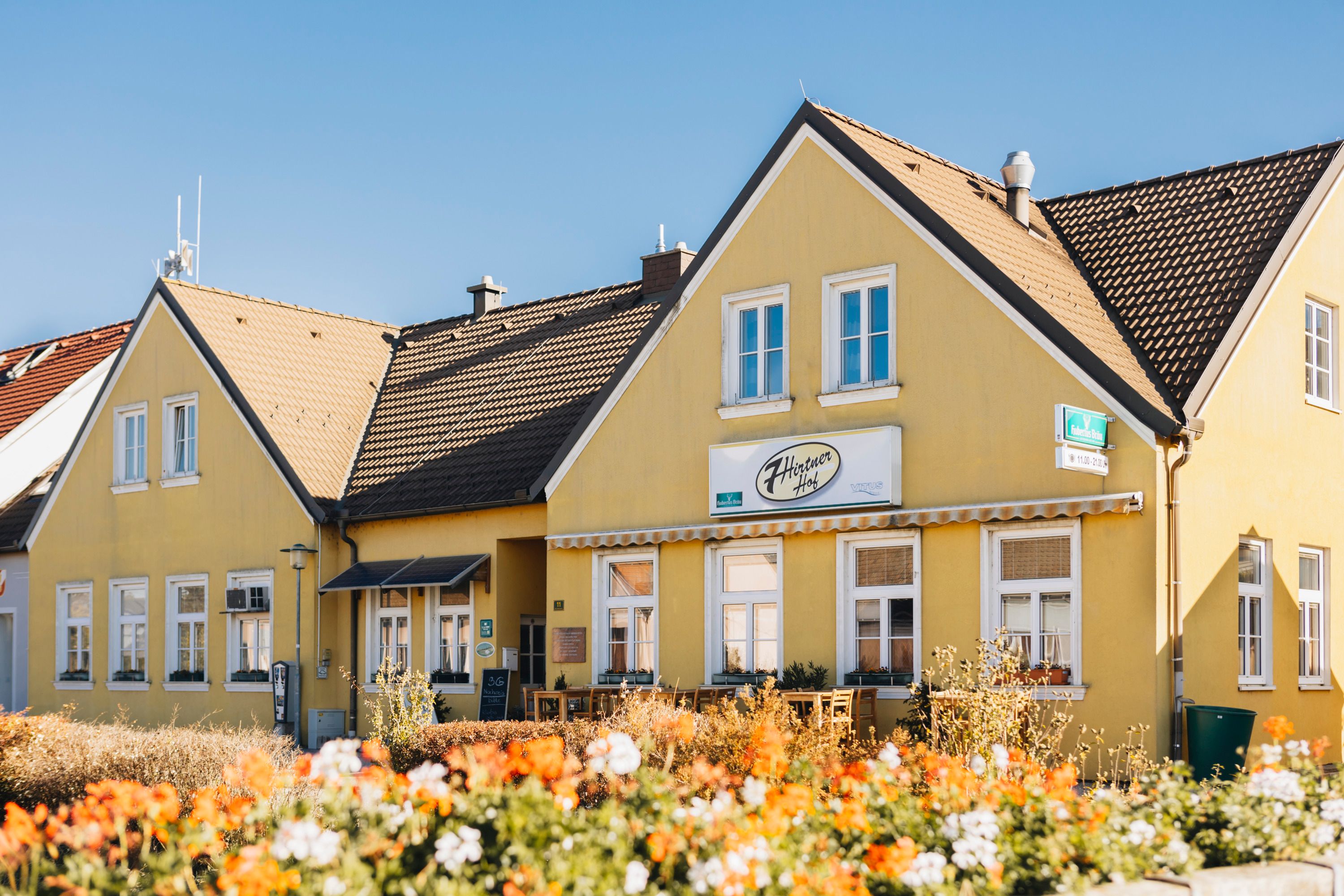 Yellow inn with flowers in the foreground.