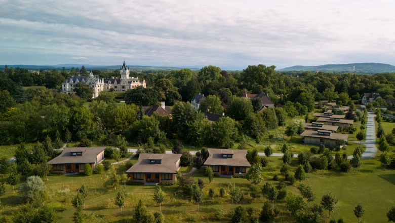 Aerial view of Grafenegg Cottages and castle surrounded by trees.