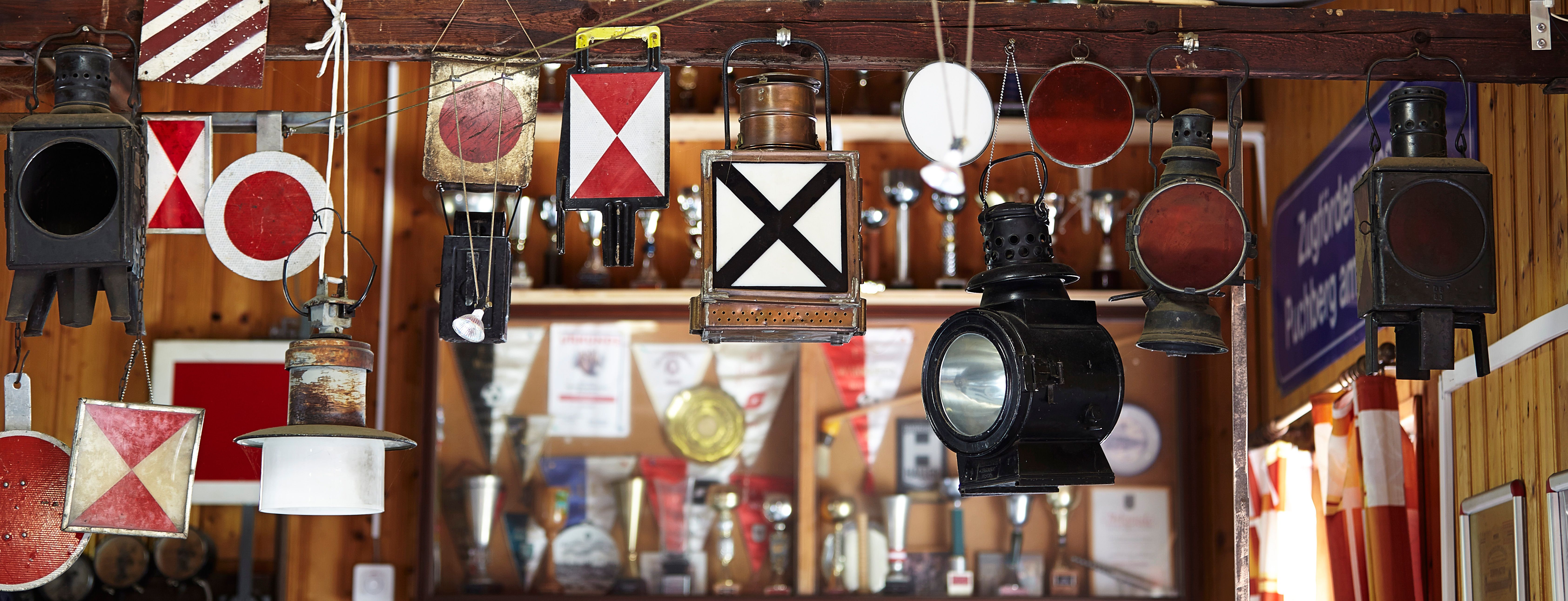 Various old railroad lamps and signals hang in an exhibition.