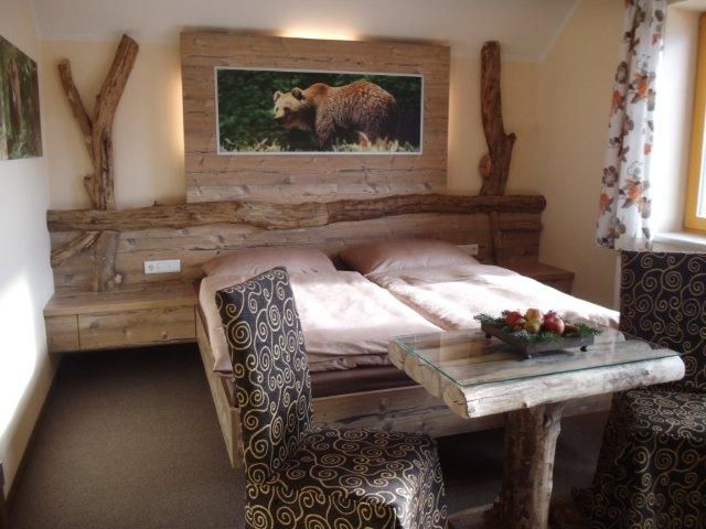 Rustic bedroom with wooden furniture and bear picture on the wall.