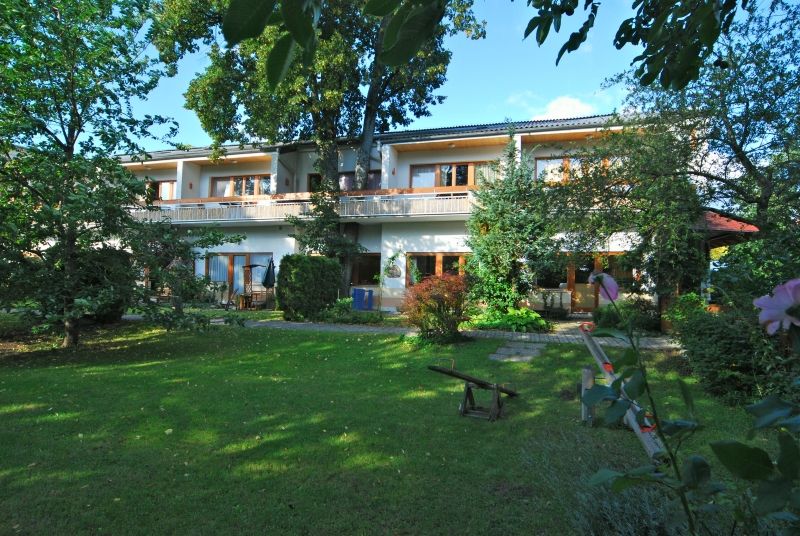 Witzmann apartment hotel with garden and trees.