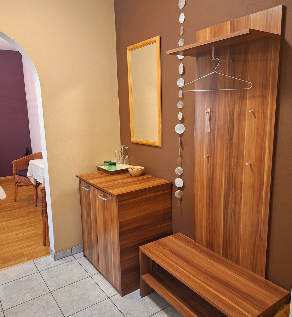 Modern entrance area with wooden furniture, mirror and decoration.