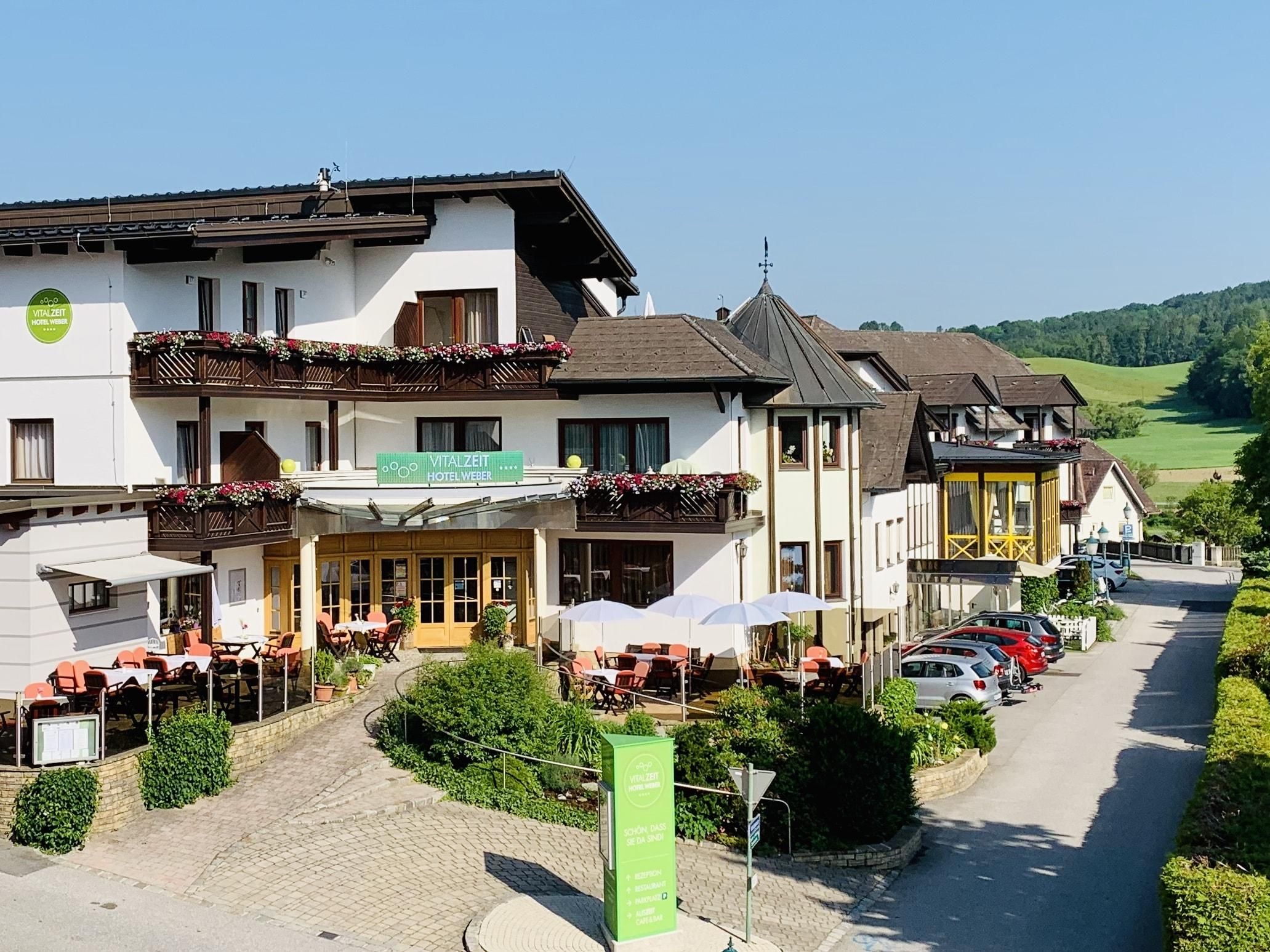 Exterior view of the VitalZeit Hotel Weber with terrace and surrounding landscape.