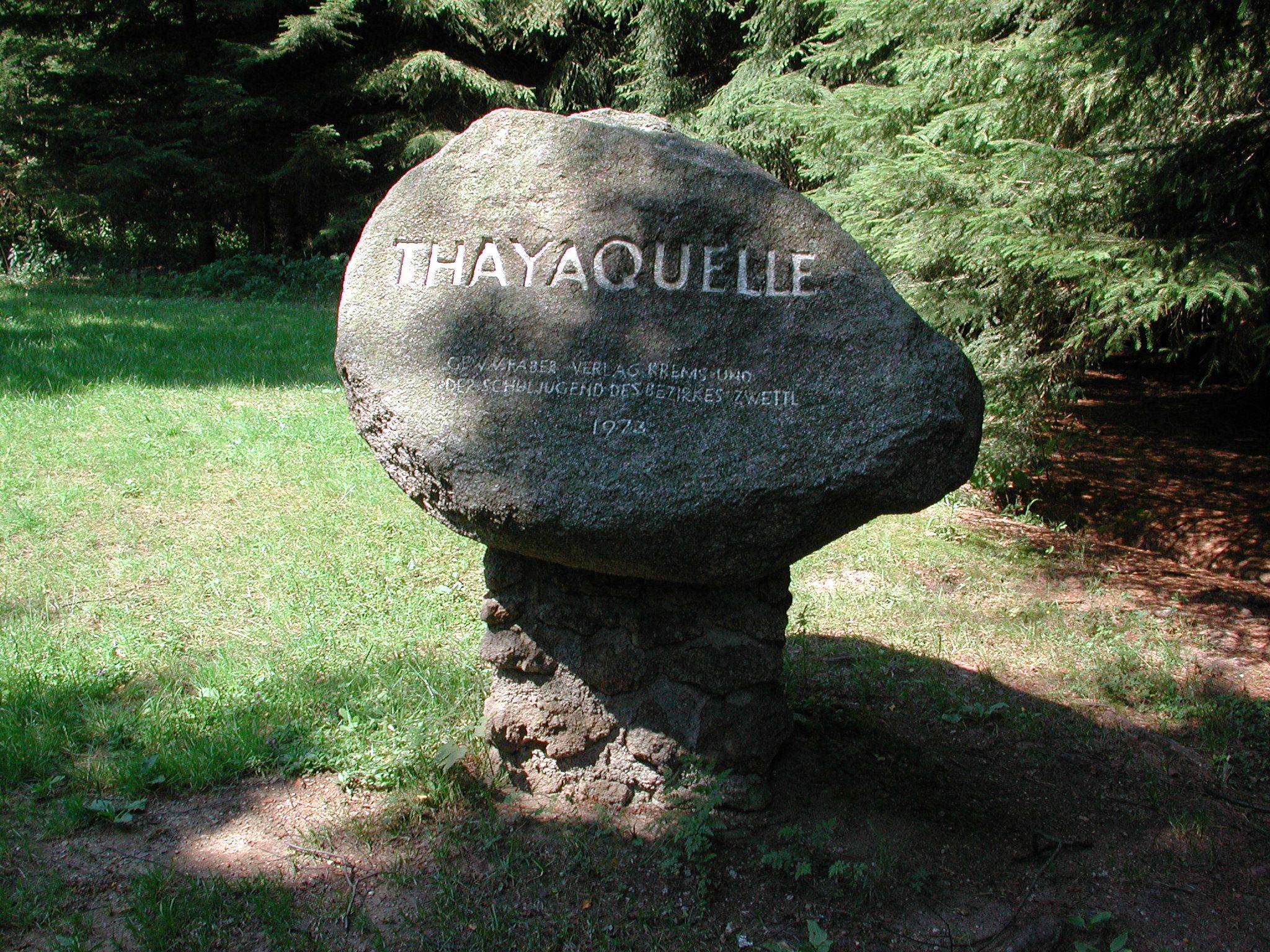A memorial stone with the inscription 'Thayaquelle' in the forest.