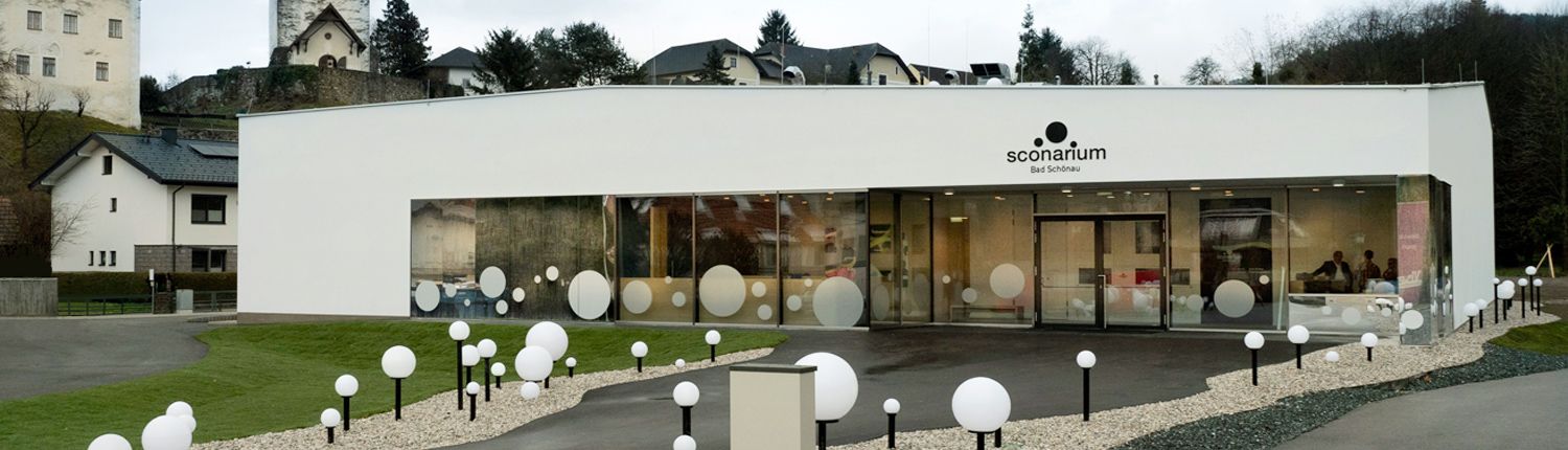 Modern building with glass front and decorative spheres in front of the entrance.