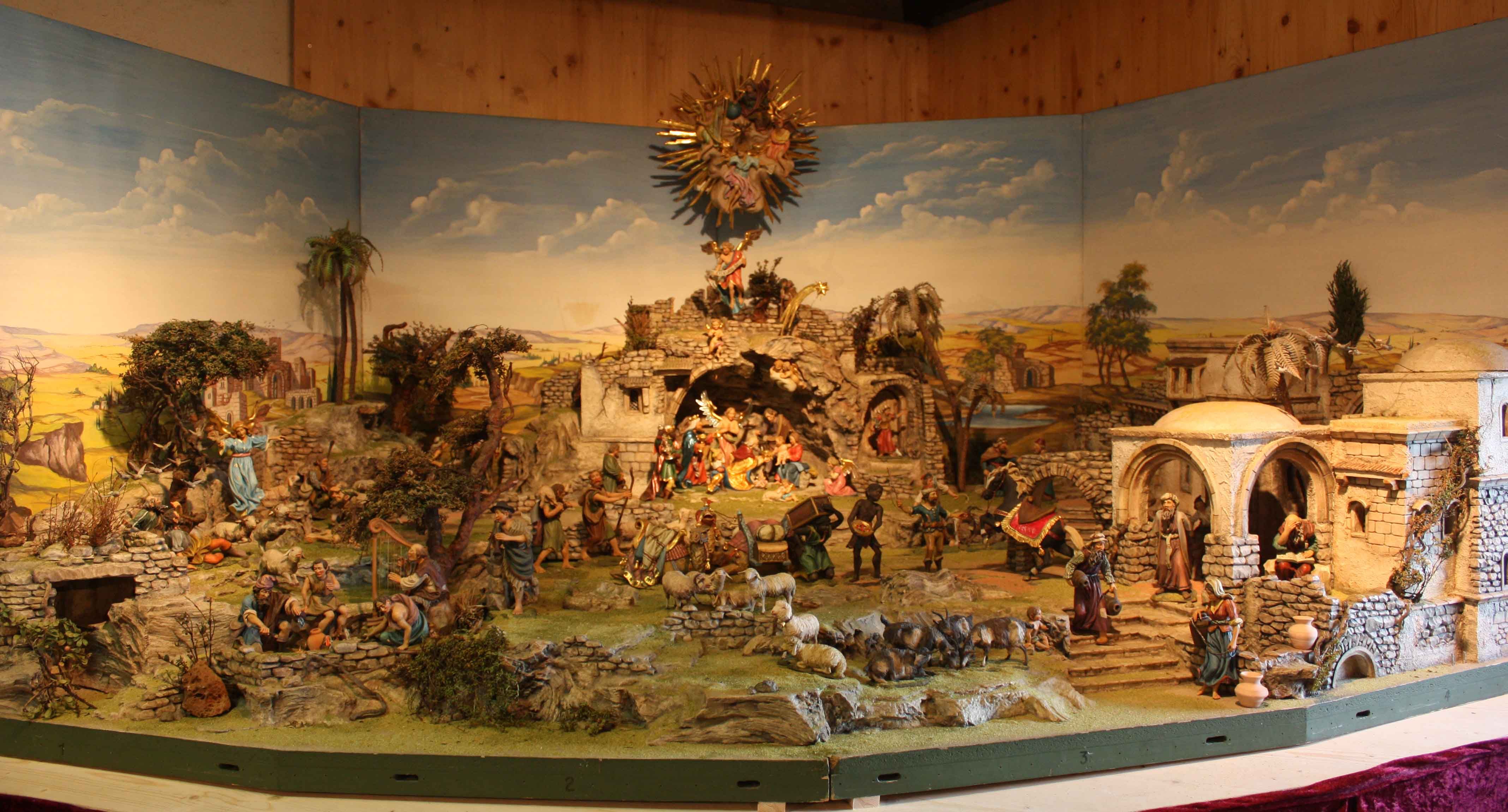 Alpine nativity scene with figures and landscape.
